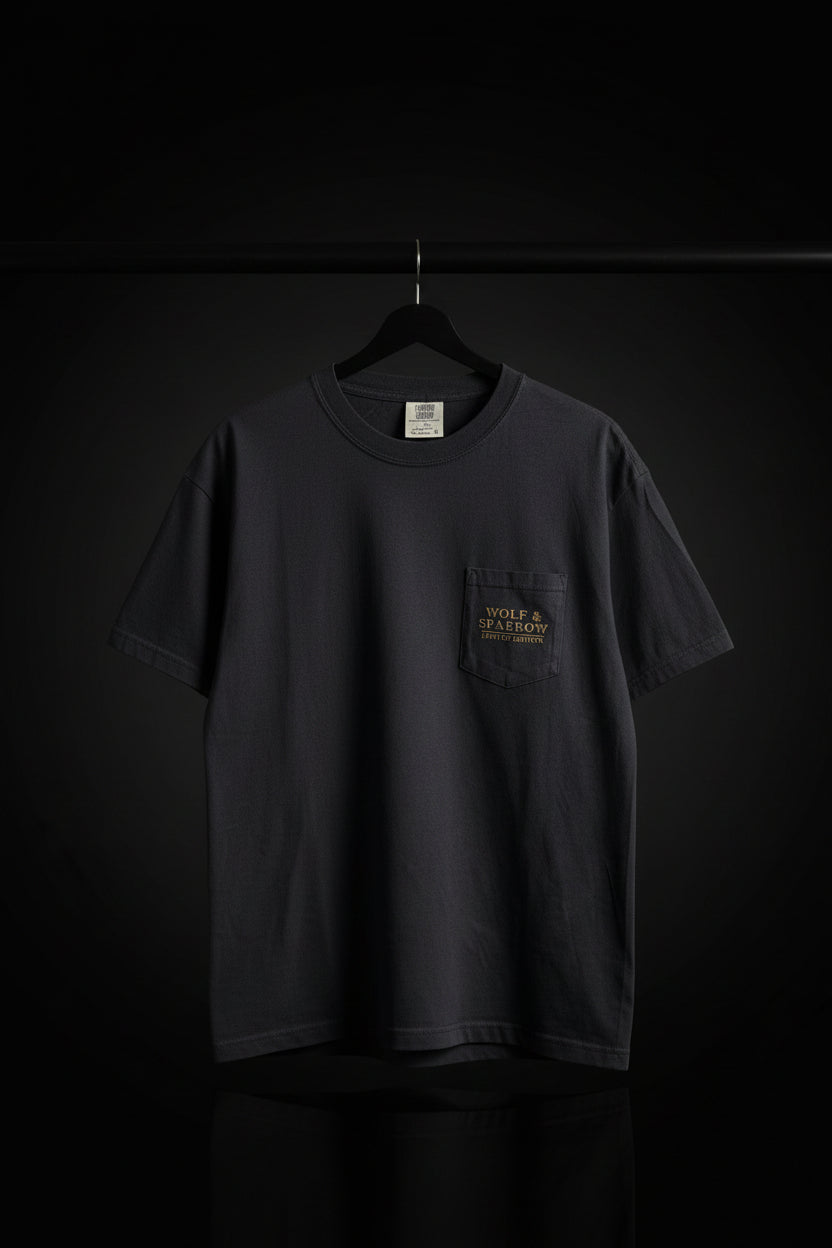 The front of a pocketed black shirt with the logo in gold that says "Wolf & Sparrow Limited Edition" against a black background