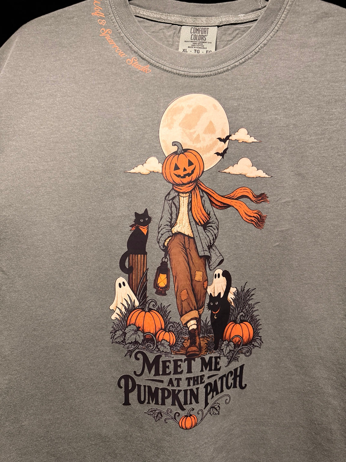 Close-up of Wolf & Sparrow Pumpkin Patch T-Shirt artwork on Moss Comfort Colors tee